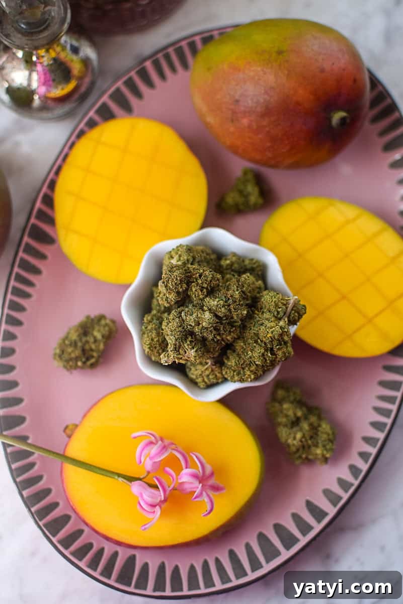 Do Mangoes Boost the Effects of Cannabis Edibles? 4 A picture of a mango and cannabis flower on a pink countertop.