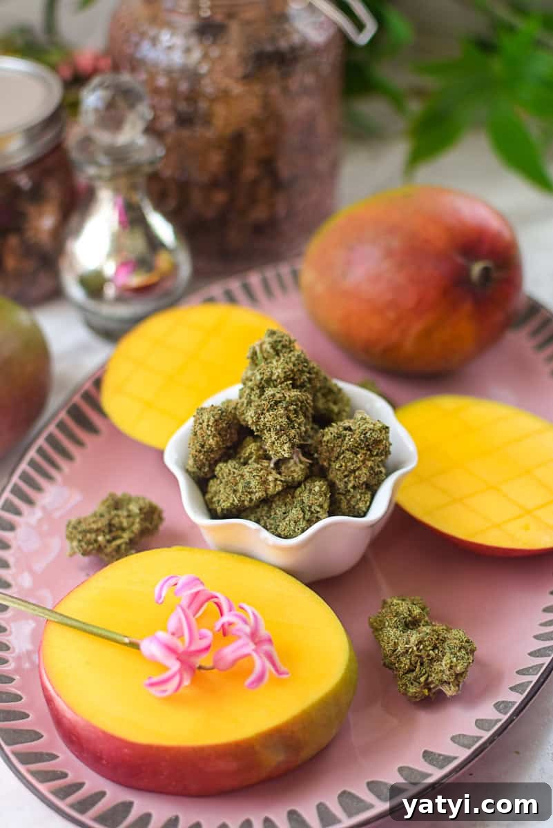 Do Mangoes Boost the Effects of Cannabis Edibles? 5 A picture of a mango and cannabis flower on a pink countertop.