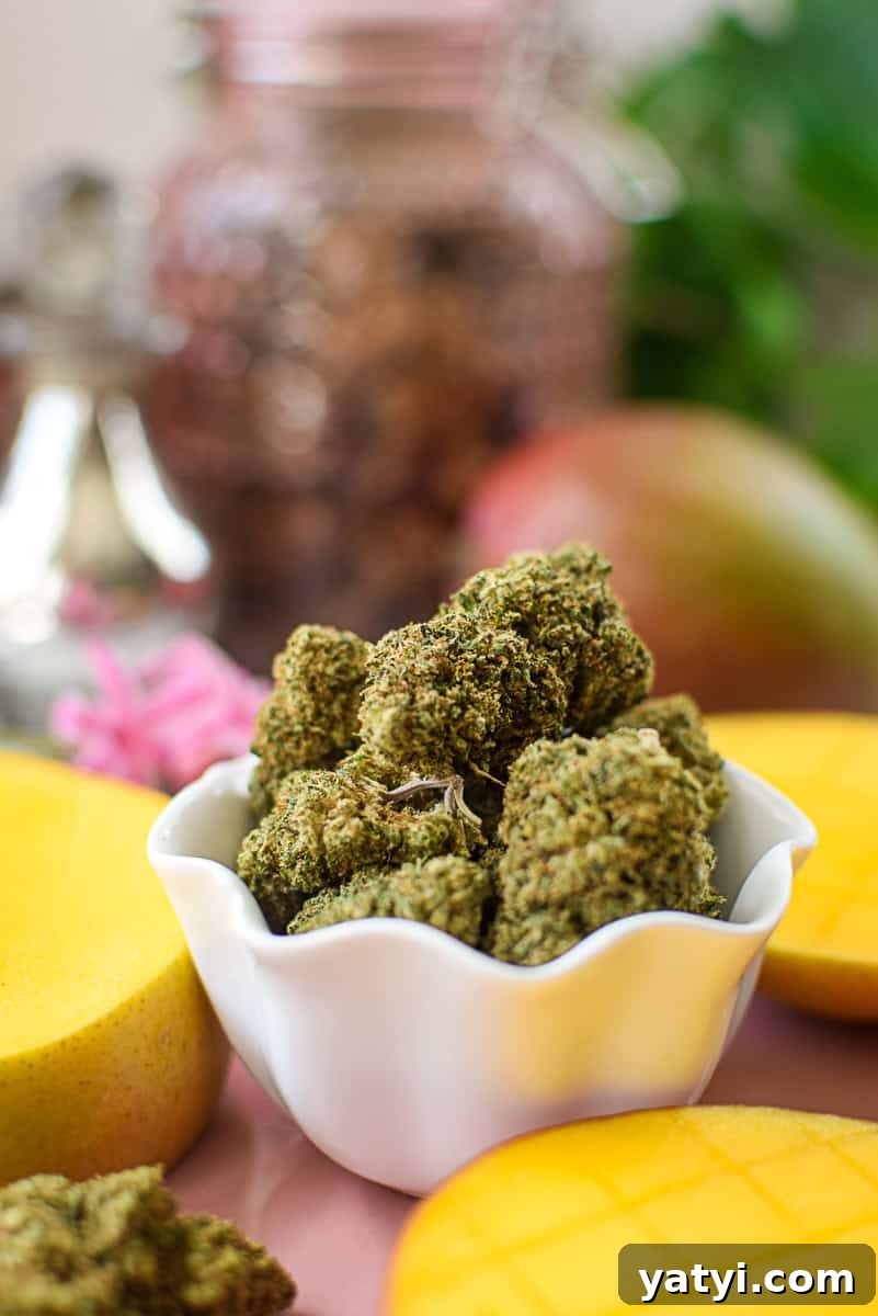 Do Mangoes Boost the Effects of Cannabis Edibles? 6 A picture of a mango and cannabis flower on a pink countertop.
