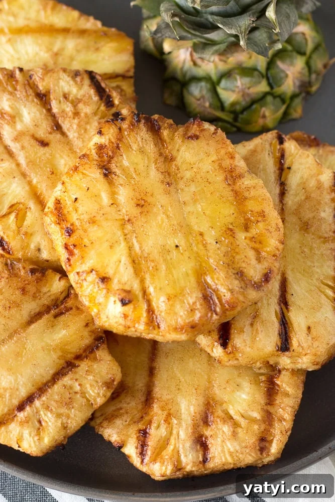 Juicy Grilled Pineapple Recipe — Naturally Sweet, No Added Sugar 2 Close up of slices of grilled pineapple on a gray plate.