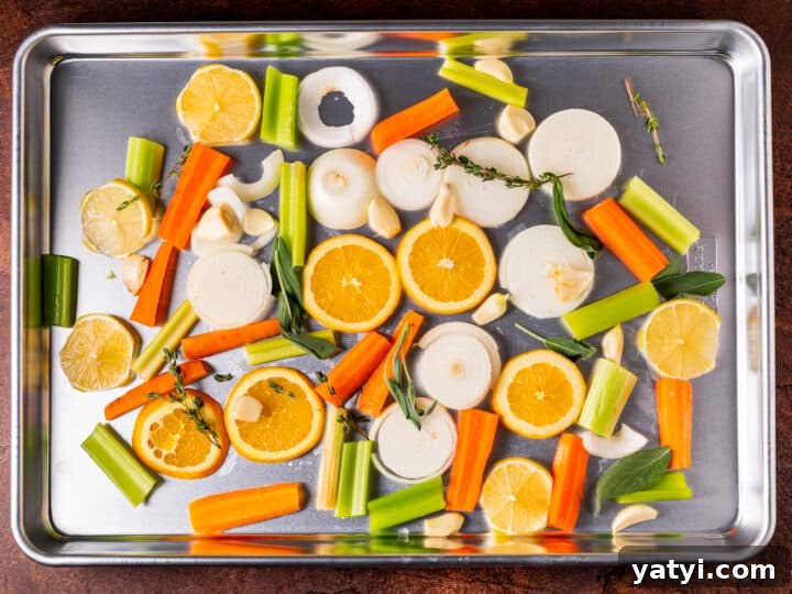 Dry-Brined Spatchcock Turkey: Complete Guide to Spatchcocking a Turkey 14 roasting pan with sliced onions, carrrots, celery, oranges, lemons and garlic cloves