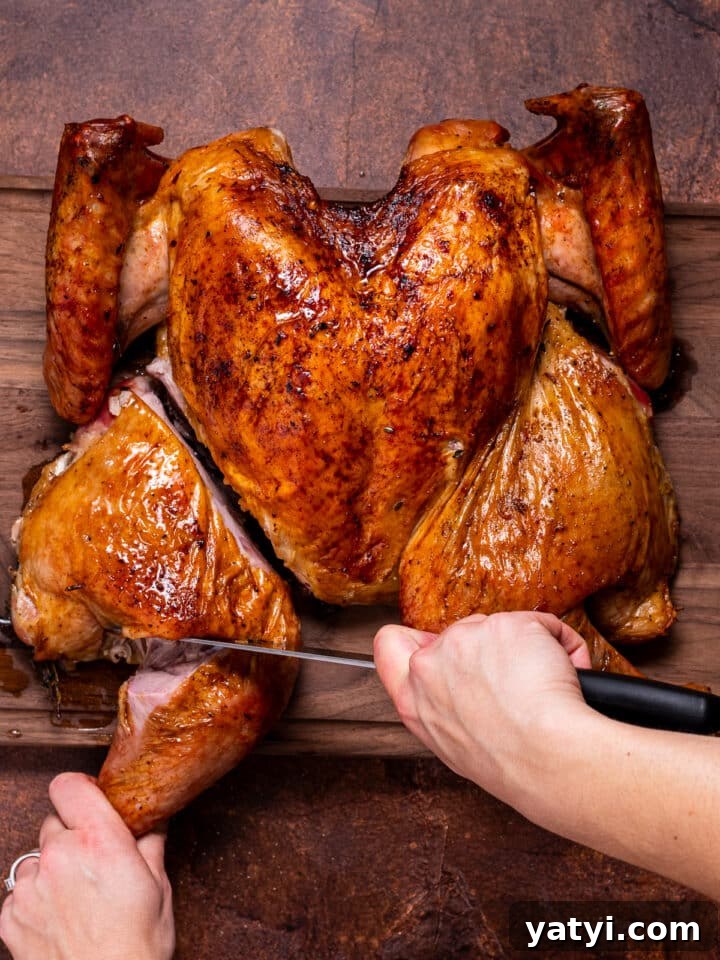 Dry-Brined Spatchcock Turkey: Complete Guide to Spatchcocking a Turkey 20 knife separating the turkey thigh from leg at its join from a dry brined spatchcock turkey