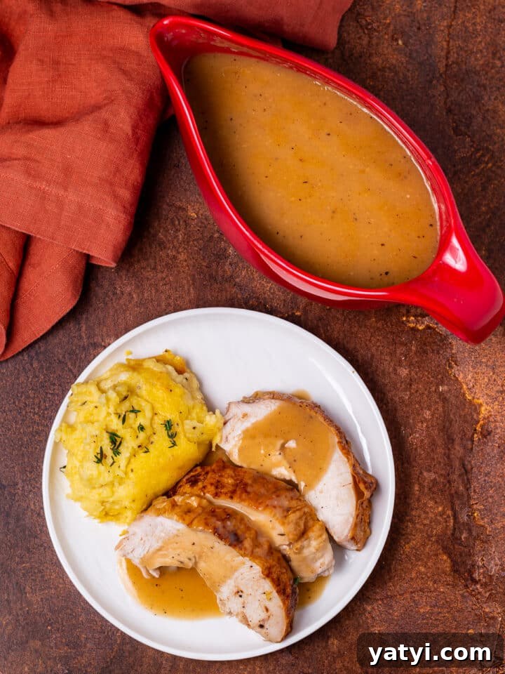 Dry-Brined Spatchcock Turkey: Complete Guide to Spatchcocking a Turkey 29 red gravy boat with gravy, white plate with turkey, gravy and mashed potatoes