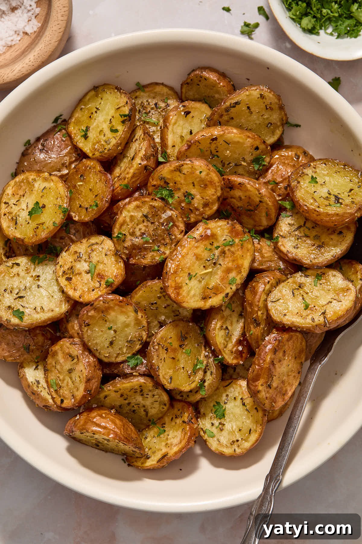 Crispy Air Fryer Baby Potatoes — 4 Ingredients Only 9 Potatoes served in a bowl with a spoon.