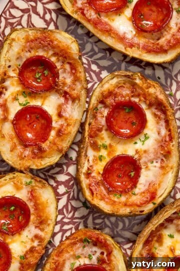 Air Fryer Pizza Potato Skins arranged on a platter and topped with chopped herbs.