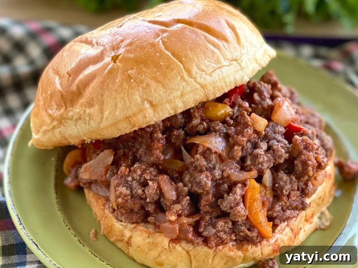10 Quick Weeknight Dinners to Save Your Evenings 2 Sloppy Joe on a brioche bun on a green plate.