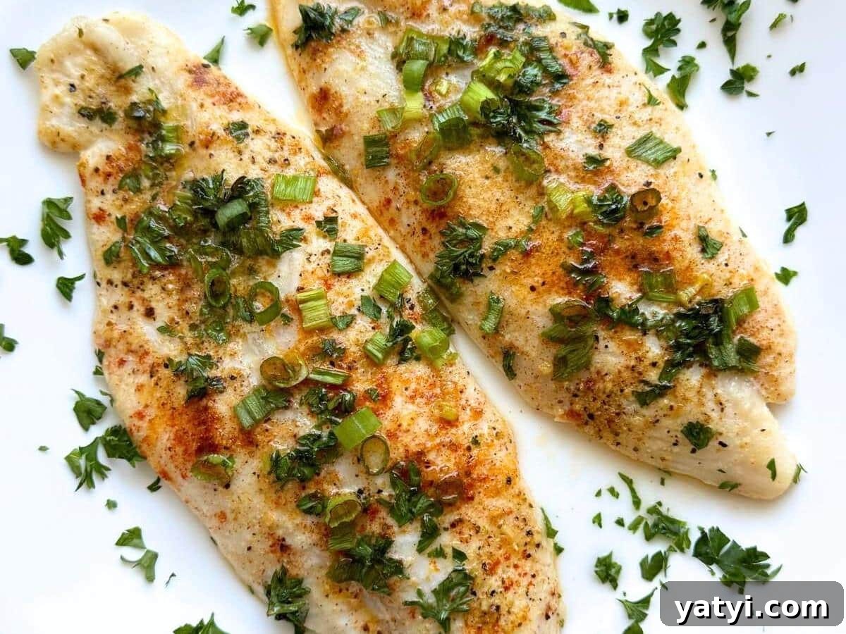 10 Quick Weeknight Dinners to Save Your Evenings 11 Two lemon pepper basa fish fillets on a white plate topped with parsley.