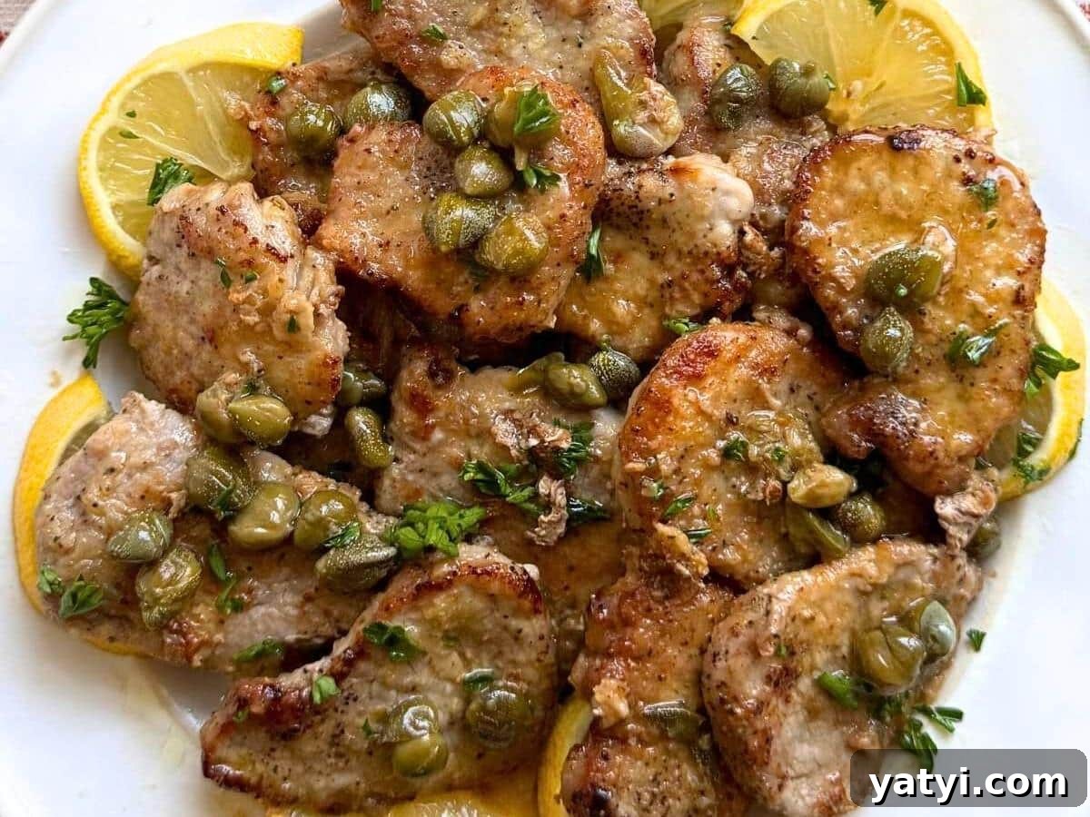 10 Quick Weeknight Dinners to Save Your Evenings 6 Pork piccata on a white plate surrounded by lemon slices.