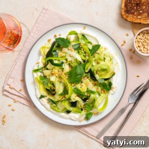 Zucchini Ribbon Salad with Whipped Lemon Ricotta Dressing 15 No-cook zucchini ribbon salad with whipped lemon ricotta, basil, mint, toasted pine nuts, and lemon zest served on a white plate.