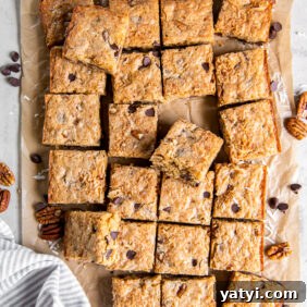 Coconut Congo Bars: Chewy Chocolate Chip Coconut Squares 11 congo bars cut into squares on parchment paper.