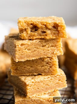 stack of peanut butter cookie bars and top bar has a bite.