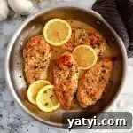 chicken with white wine sauce topped with lemon and parsley