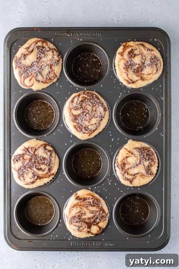 Nutella Swirl Muffins Recipe: Moist Chocolate-Hazelnut Muffins 12 a muffin pan with nutella swirl muffin batter in every other hole with sanding sugar on top