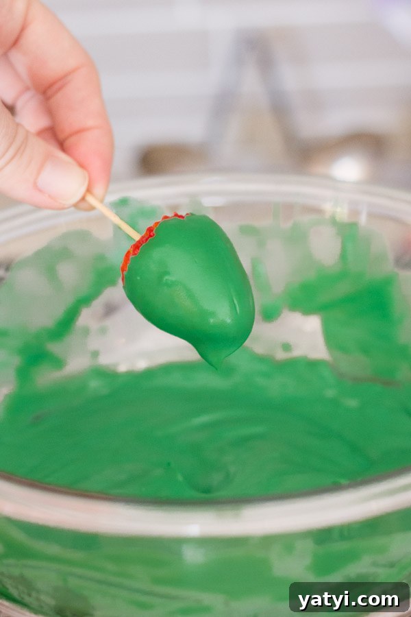 Chocolate-Covered Strawberry Christmas Tree Treats 4 A strawberry on a toothpick covered with the candy coating.