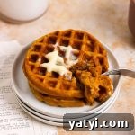 A stack of mini pumpkin waffles with butter.