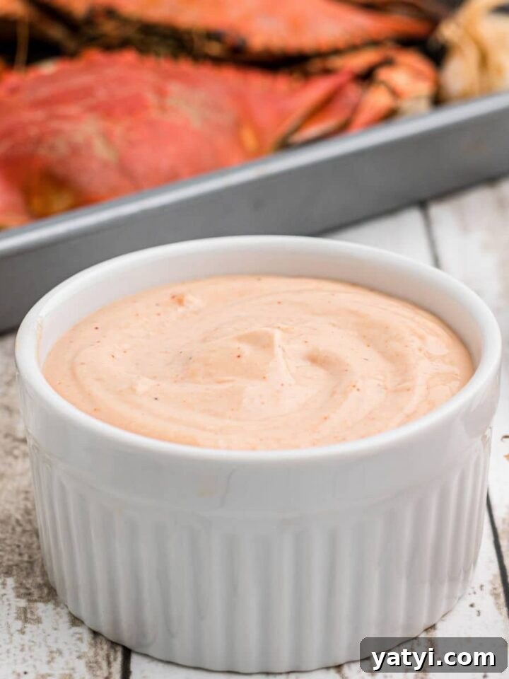 A bowl of seafood sauce with some boiled crabs in the background