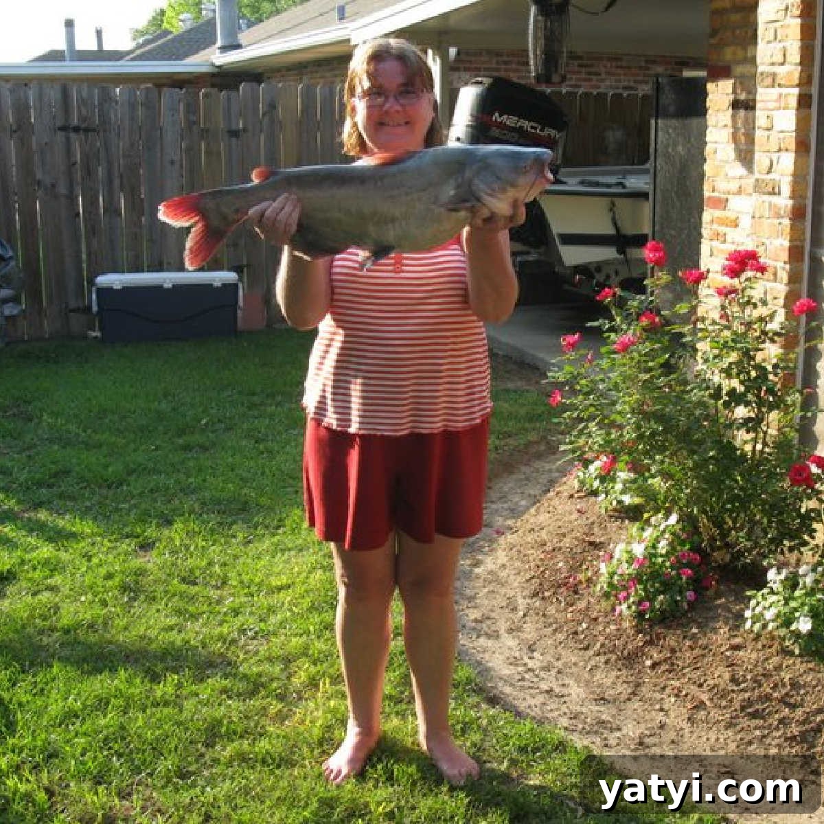 Crispy Southern Fried Catfish Nuggets with Tangy Dipping Sauce 15 A picture of Melanie Cagle's mom, holding a large catfish, in the backyard.