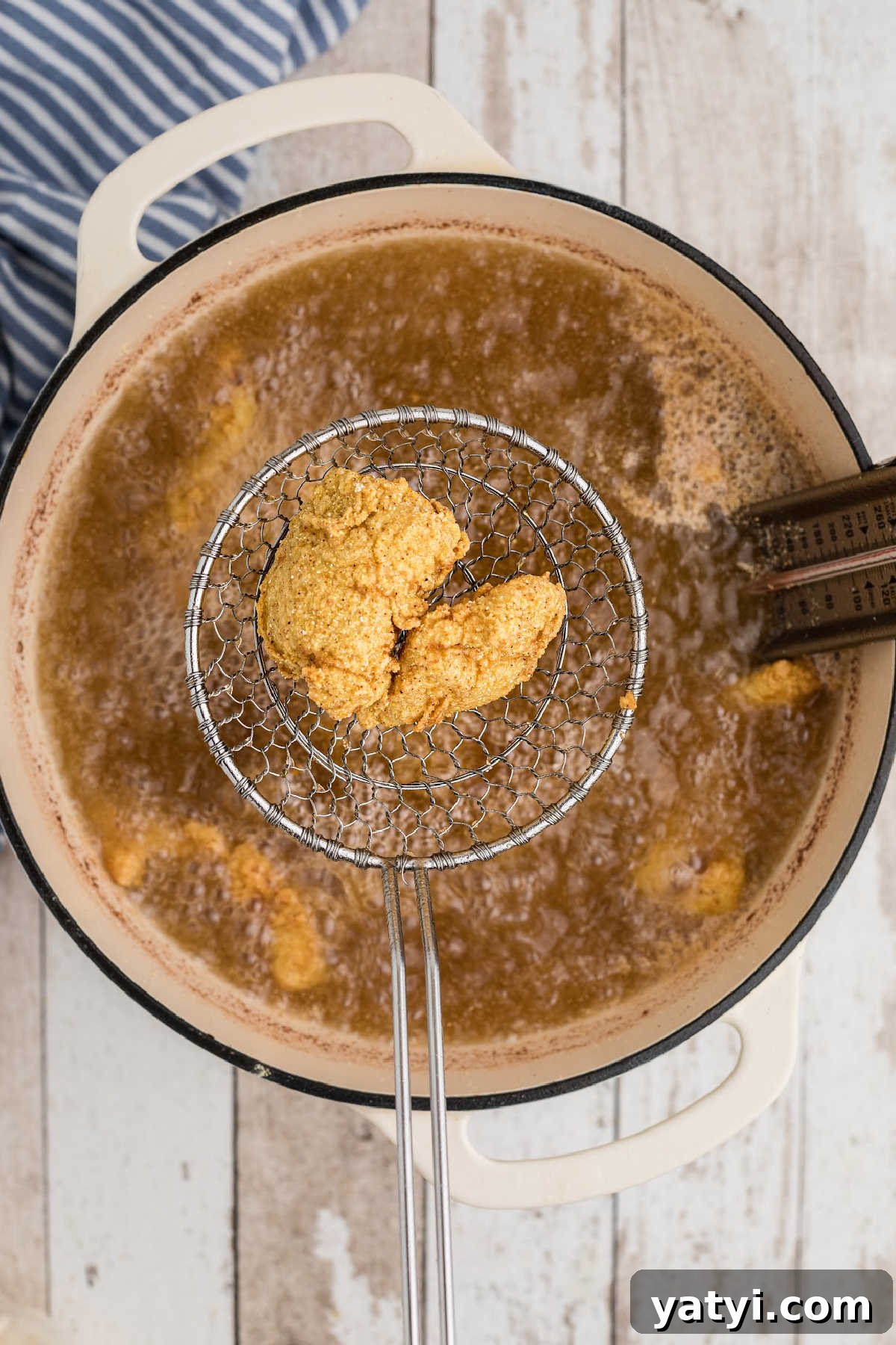 Crispy Southern Fried Catfish Nuggets with Tangy Dipping Sauce 7 A pot full of grease, frying some catfish fillets.