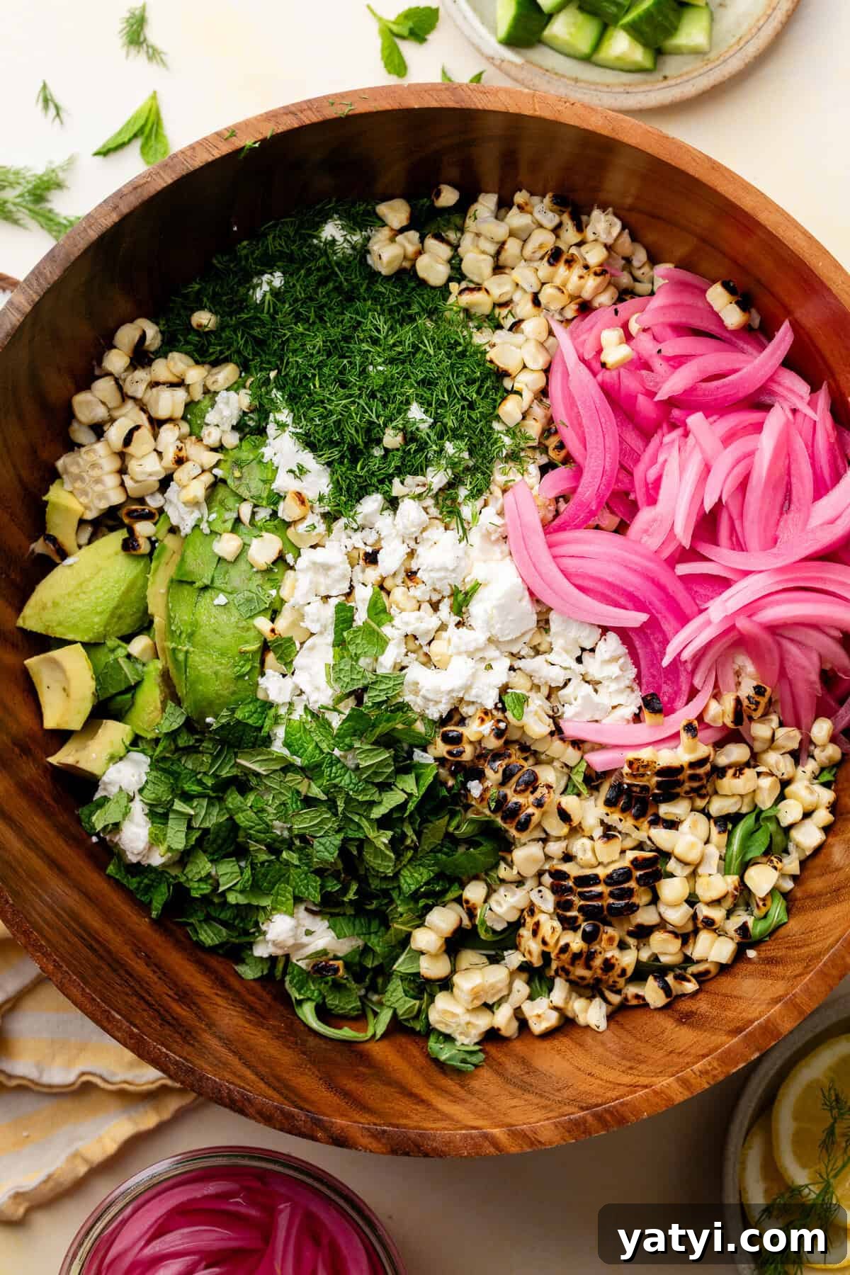Corn Avocado Feta Dill Salad ingredients in wooden bowl.