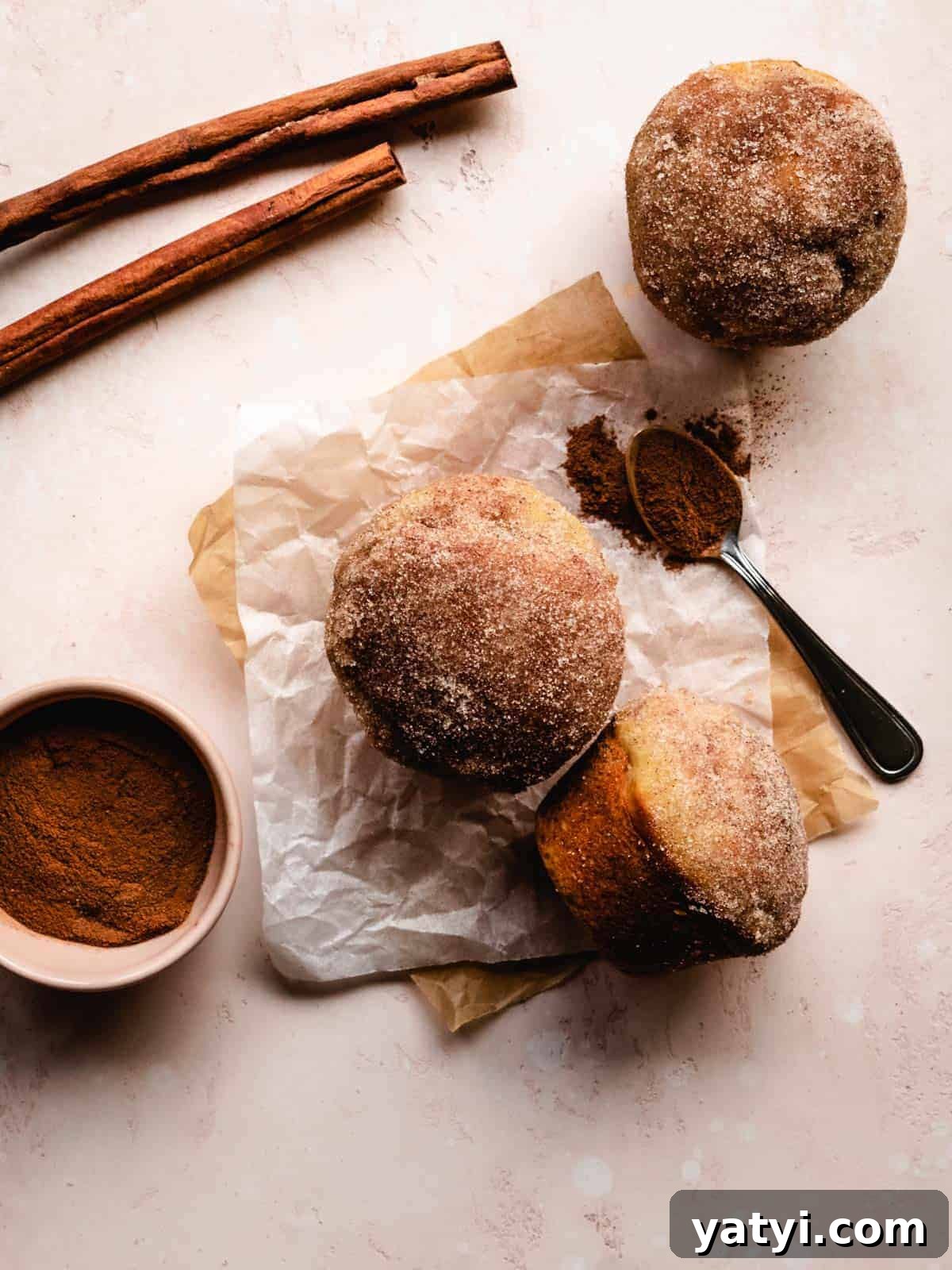 Cinnamon Sugar Donut Muffins Recipe — Soft Baked Donut-Style Muffins 3 cinnamon sugar donut muffins with cinnamon and cinnamon sticks around