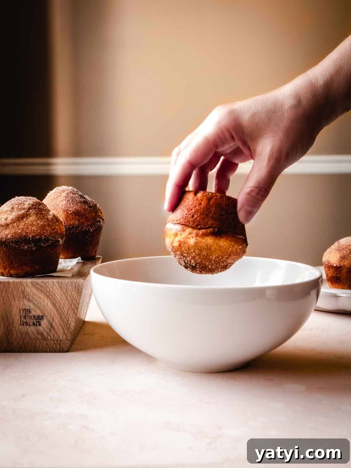 Cinnamon Sugar Donut Muffins Recipe — Soft Baked Donut-Style Muffins 7 dipping donut muffin in melted butter and cinnamon sugar