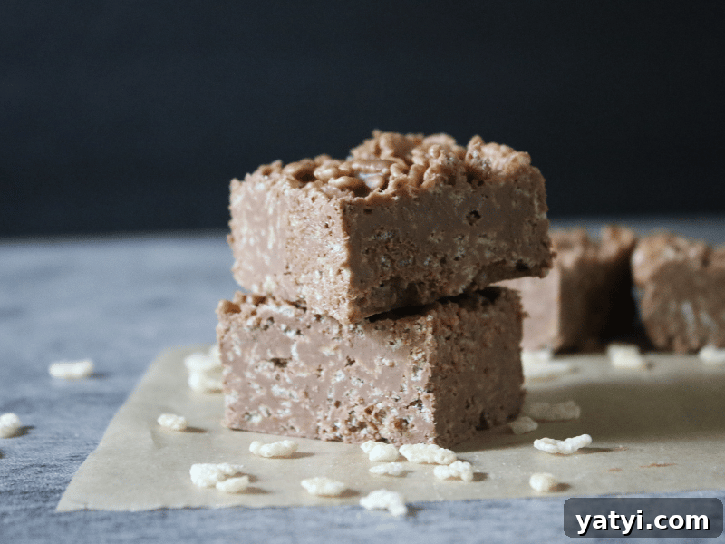 No-Bake Homemade Crunch Bars Recipe for Crispy Chocolate Treats 6 Homemade crunch bars stacked on parchment paper.