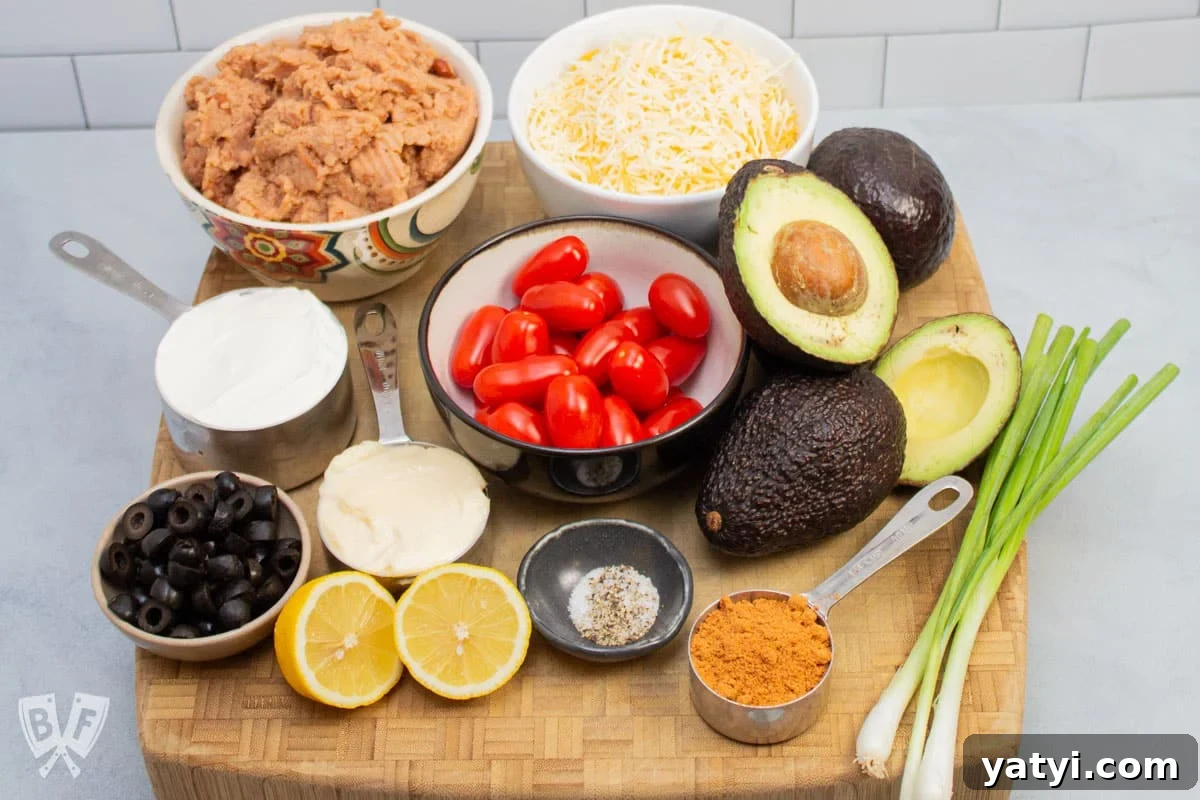 Layered Taco Dip with Refried Beans for Parties and Game Day 3 Overhead view of ingredients needed to make a layered taco dip with refried beans.