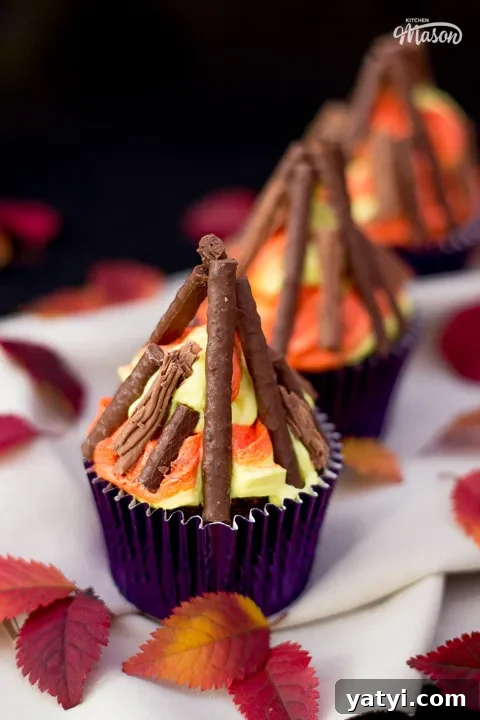 Bonfire Cupcakes Recipe: How to Make Campfire-Style Treats 2 Three bonfire cupcakes on a beige cloth, surrounded by red leaves.