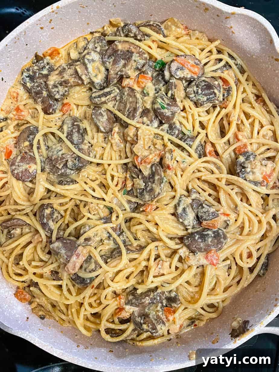 overhead shot of Mushroom sauce combined with pasta in a skillet.
