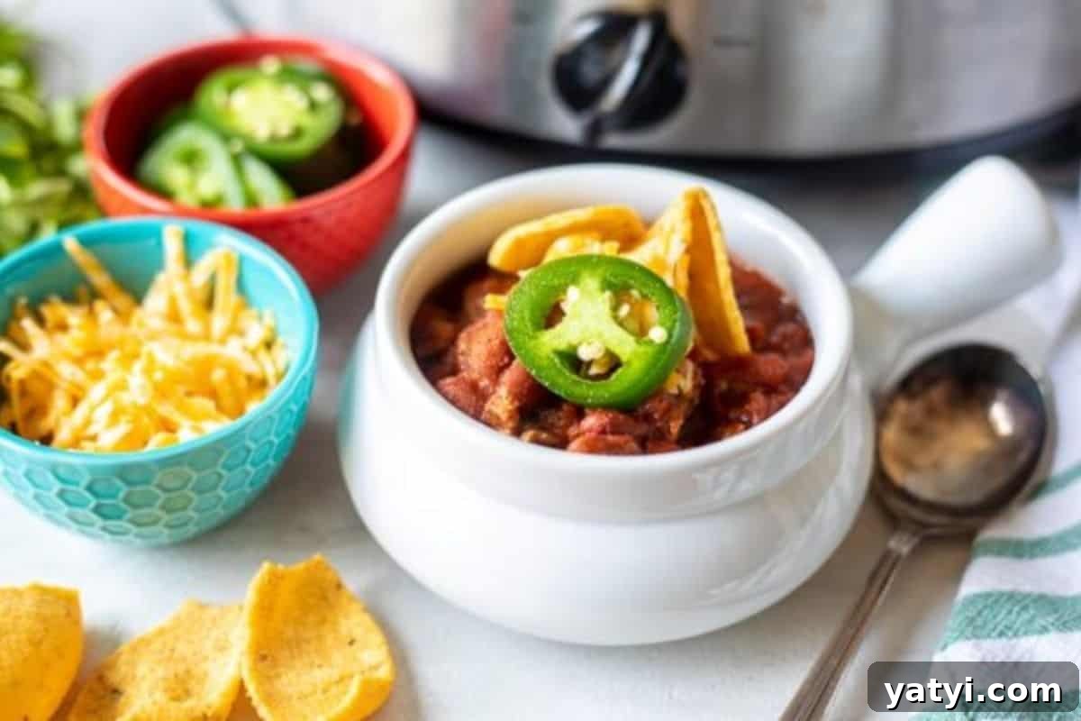 Best Chili Recipes Bowl of chili topped with corn chips and jalapenos.