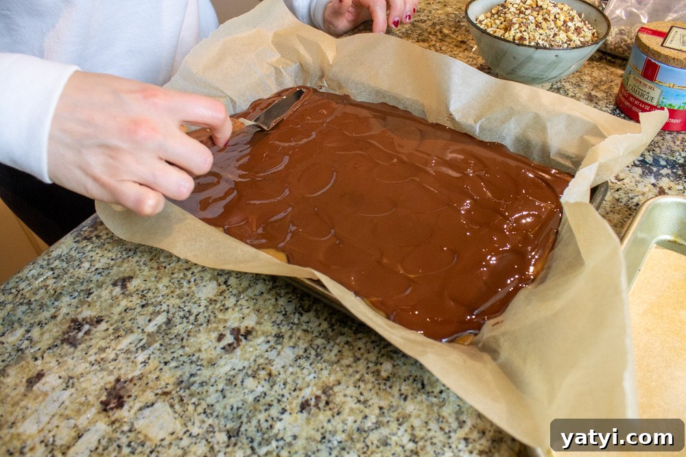 Dark Chocolate Almond Toffee: Crunchy Homemade Recipe 7 spreading chocolate over toffee