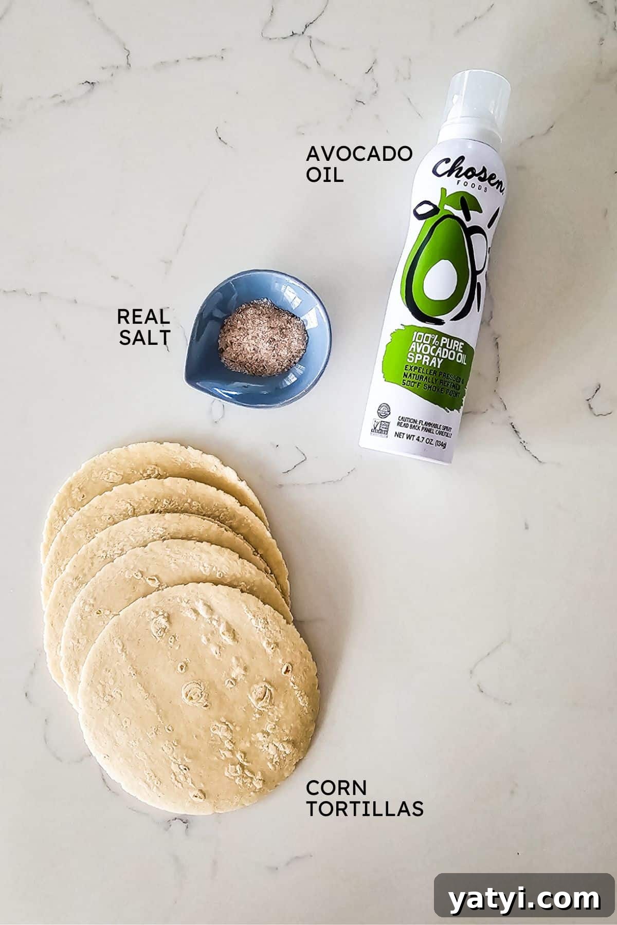 Crispy Oven-Baked Tortilla Chips Recipe You Can Make at Home 3 Ingredients to make tortilla chips on a counter top including avocado oil, salt, and tortillas.