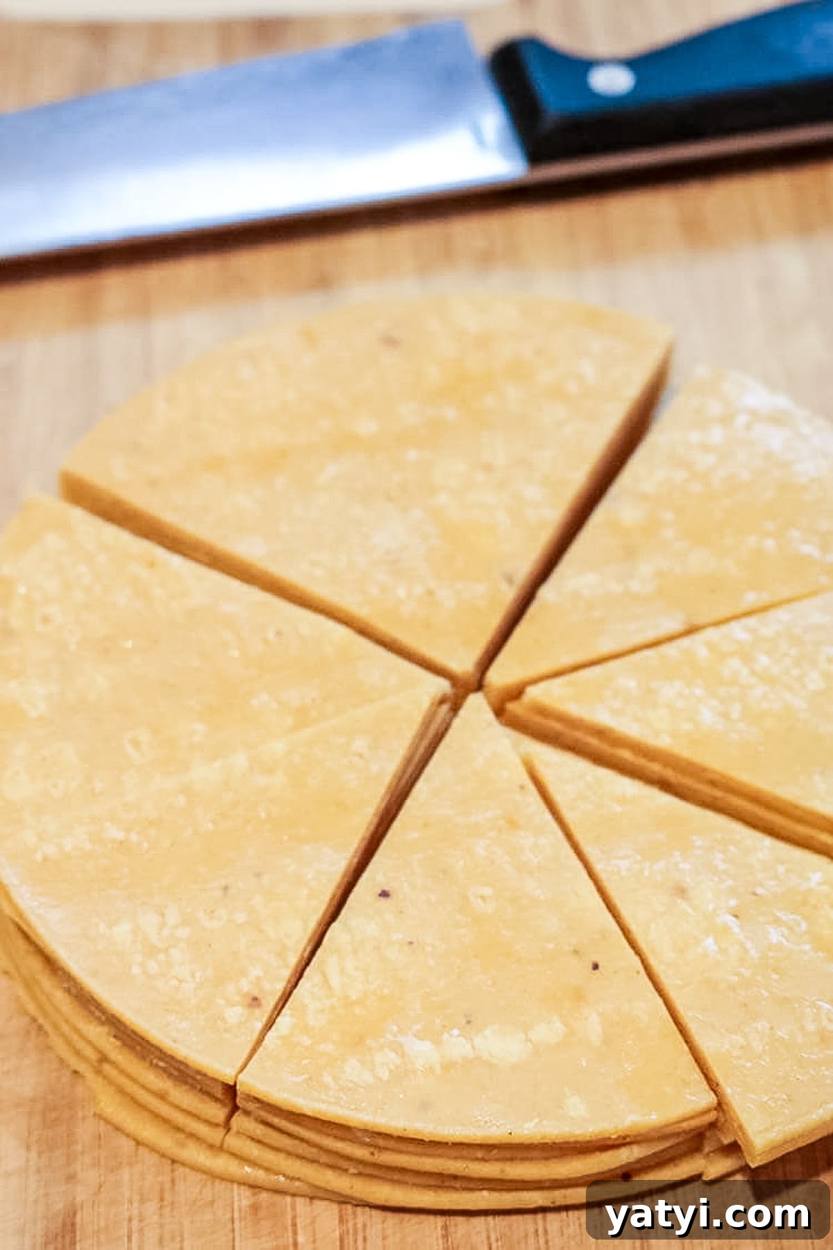 Crispy Oven-Baked Tortilla Chips Recipe You Can Make at Home 5 corn tortillas that are cut into 8ths on top of a cutting board.