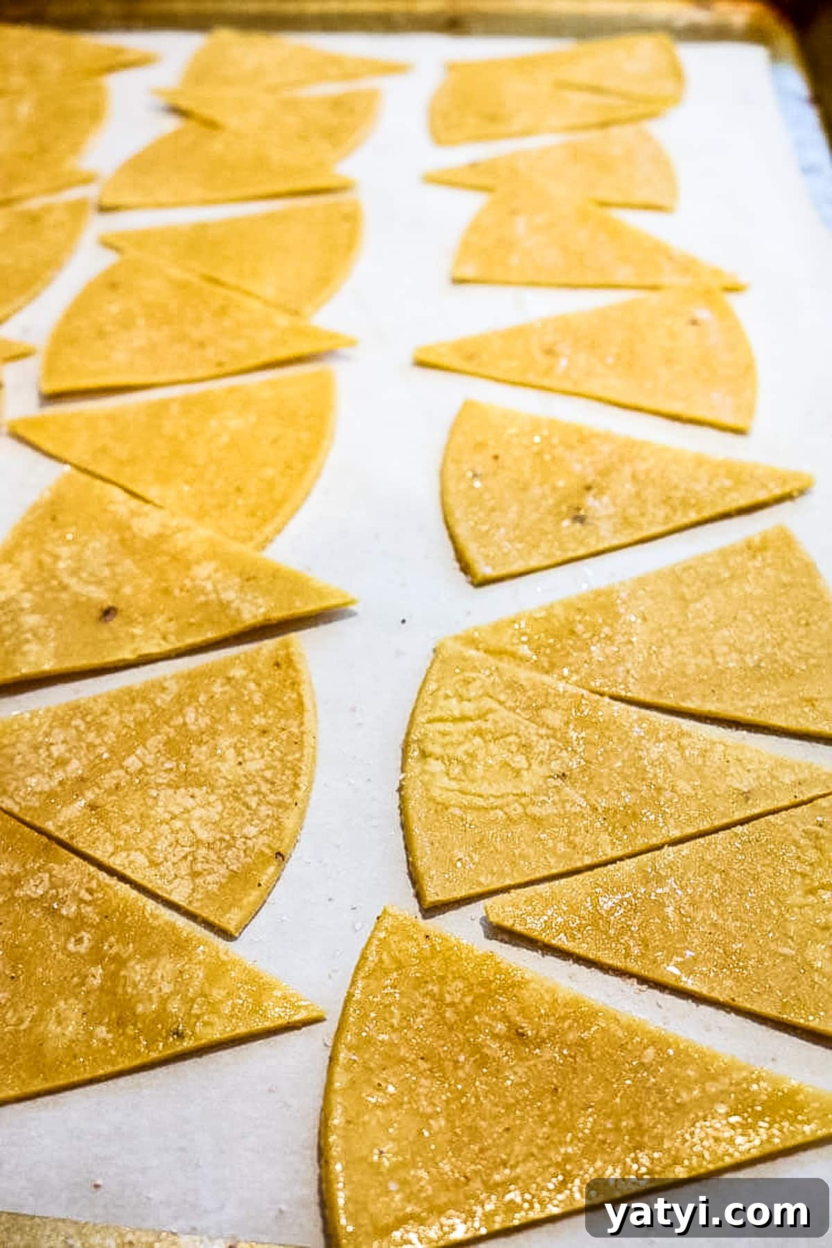 Crispy Oven-Baked Tortilla Chips Recipe You Can Make at Home 6 Cut up tortillas on a baking sheet.