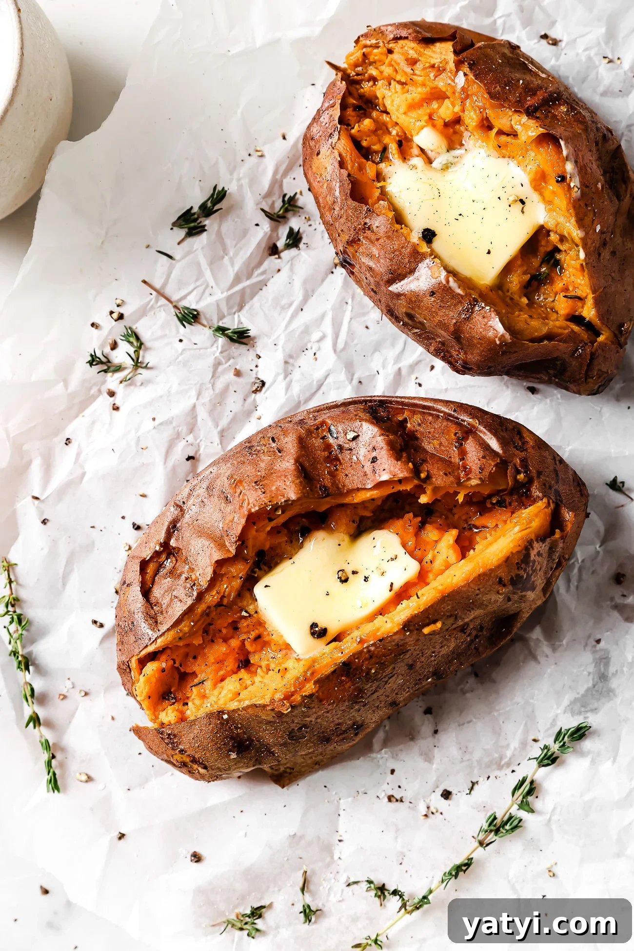 Crispy Air Fryer Sweet Potatoes: Quick Roast in 20 Minutes 2 Two air fryer baked sweet potatoes topped with butter and herbs.