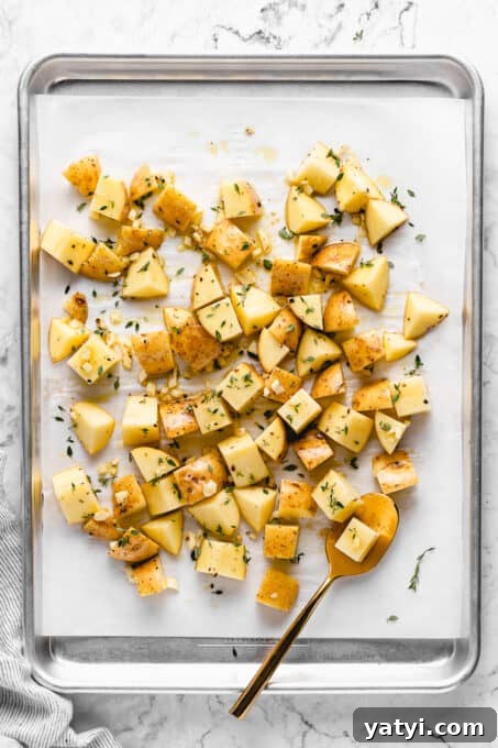 Bake. ingredients for garlic roasted potatoes on a lined cookie sheet