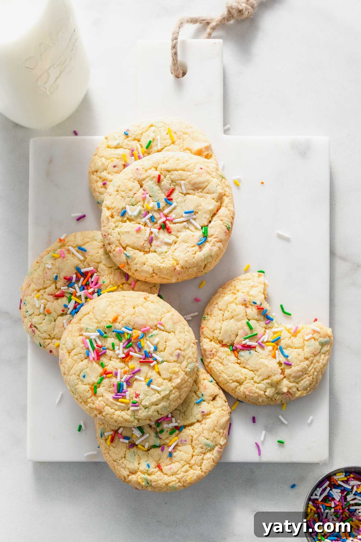 Chewy Yellow Cake Mix Cookies Recipe with Simple Ingredients 2 yellow cake mix cookies on a board.