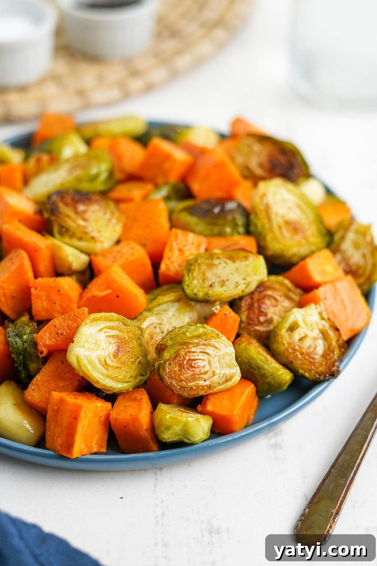 Crispy Roasted Brussels Sprouts with Maple-Roasted Sweet Potatoes 2 Bowl of cooked brussels sprouts and sweet potatoes on the table.