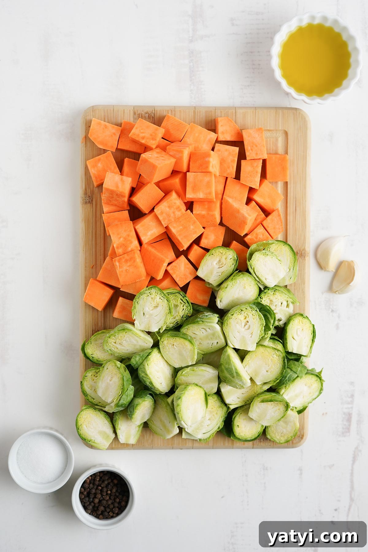 Crispy Roasted Brussels Sprouts with Maple-Roasted Sweet Potatoes 4 Cutting up the vegetables to make brussel sprouts with sweet potatoes.