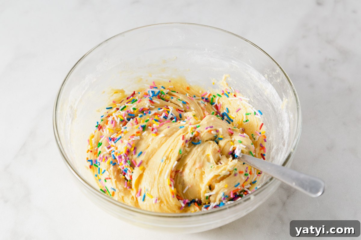 Chewy Yellow Cake Mix Cookies Recipe with Simple Ingredients 6 adding sprinkles to the yellow cake mix cookie dough.