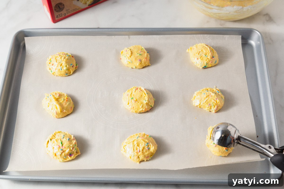 Chewy Yellow Cake Mix Cookies Recipe with Simple Ingredients 7 scooping the yellow cake mix cookie dough to the baking sheet.