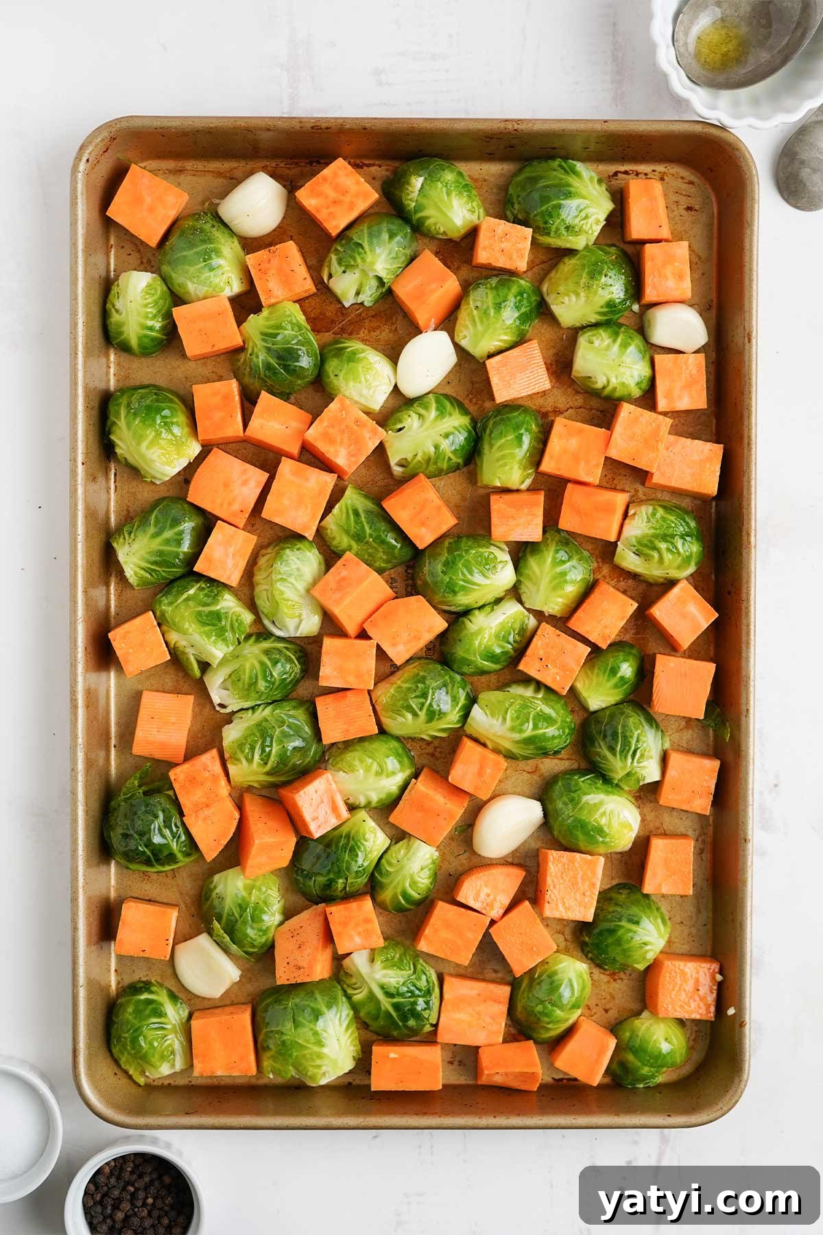 Crispy Roasted Brussels Sprouts with Maple-Roasted Sweet Potatoes 5 Sweet potatoes and brussel sprouts on a pan.