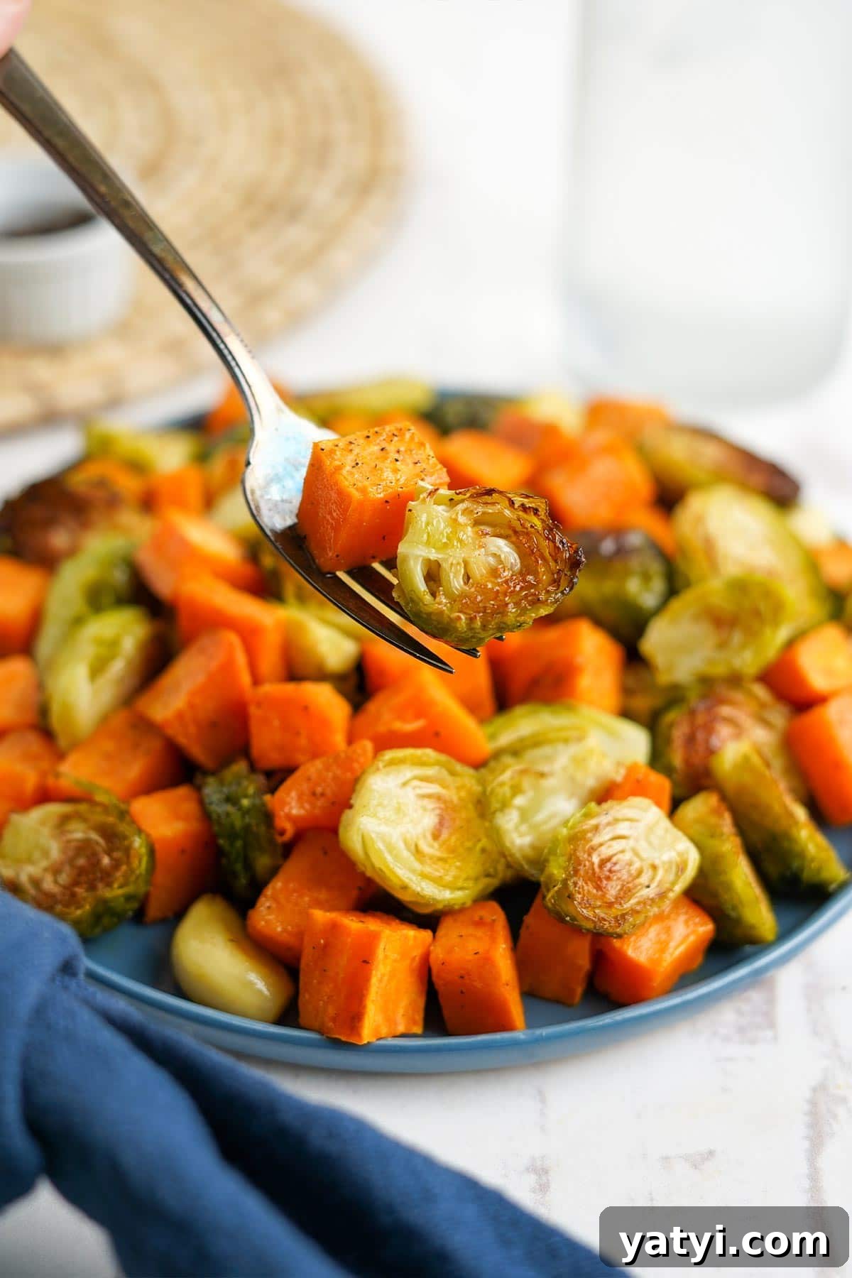 Crispy Roasted Brussels Sprouts with Maple-Roasted Sweet Potatoes 6 Close up of bite of roasted sweet potatoes and brussel sprouts on a fork.