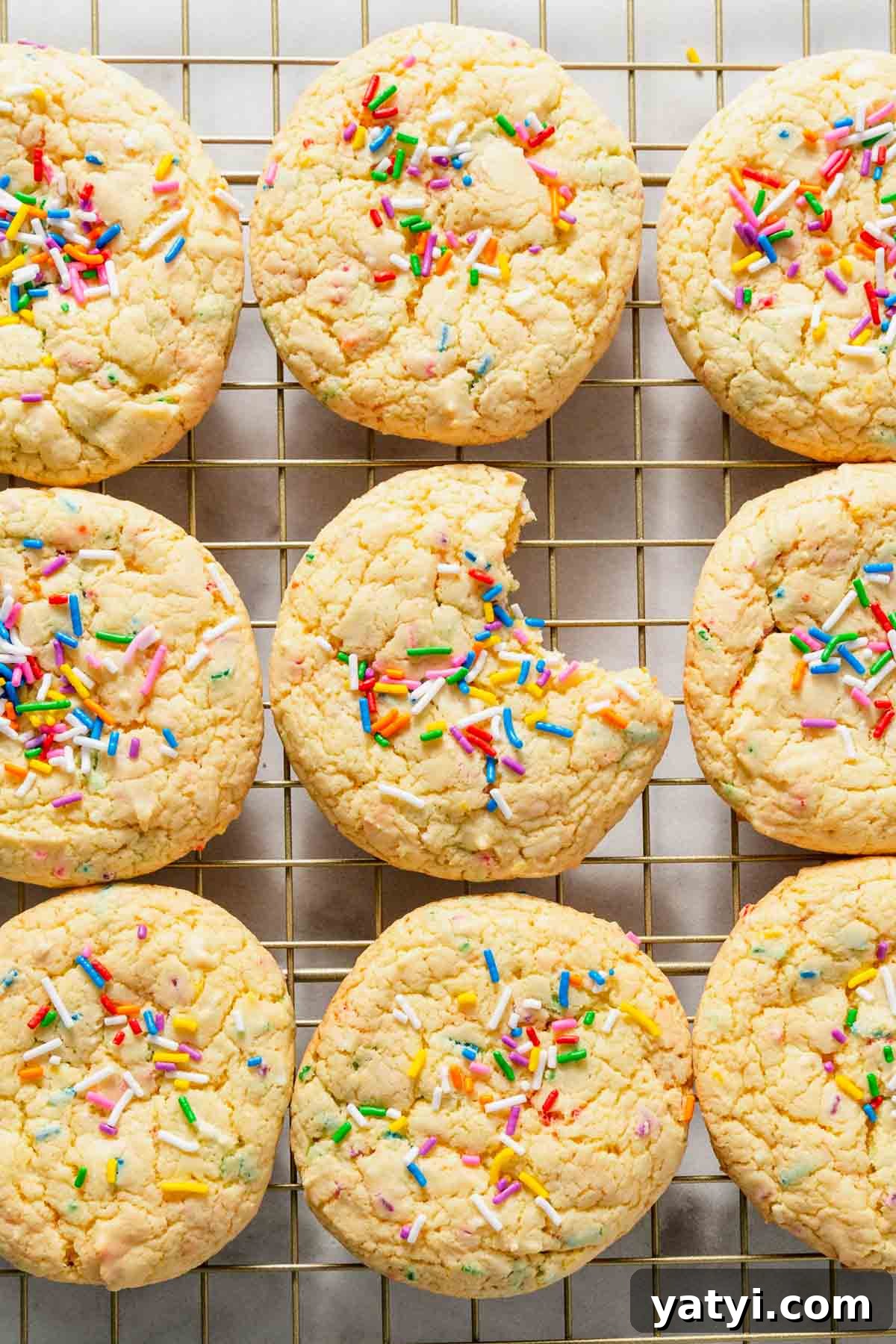 Chewy Yellow Cake Mix Cookies Recipe with Simple Ingredients 10 yellow cake mix cookies with sprinkles on a cooling rack.