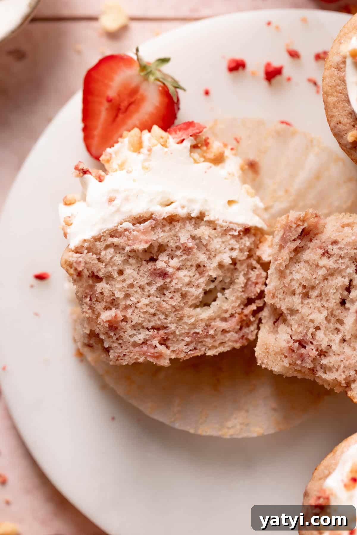 Strawberry Crunch Cupcakes Recipe with Crispy Topping 11 strawberry shortcake cupcake cut in half on a white plate.