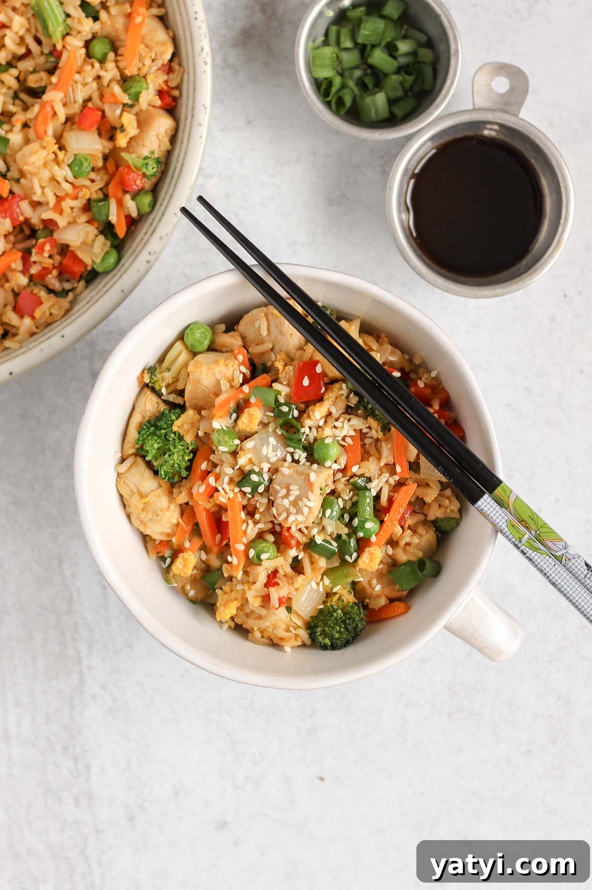 Low-Sodium Fried Rice Without Soy Sauce — Flavorful Vegetable Fried Rice 9 Chicken fried rice with lots of veggies in a single serve dish with chopsticks laid on top.