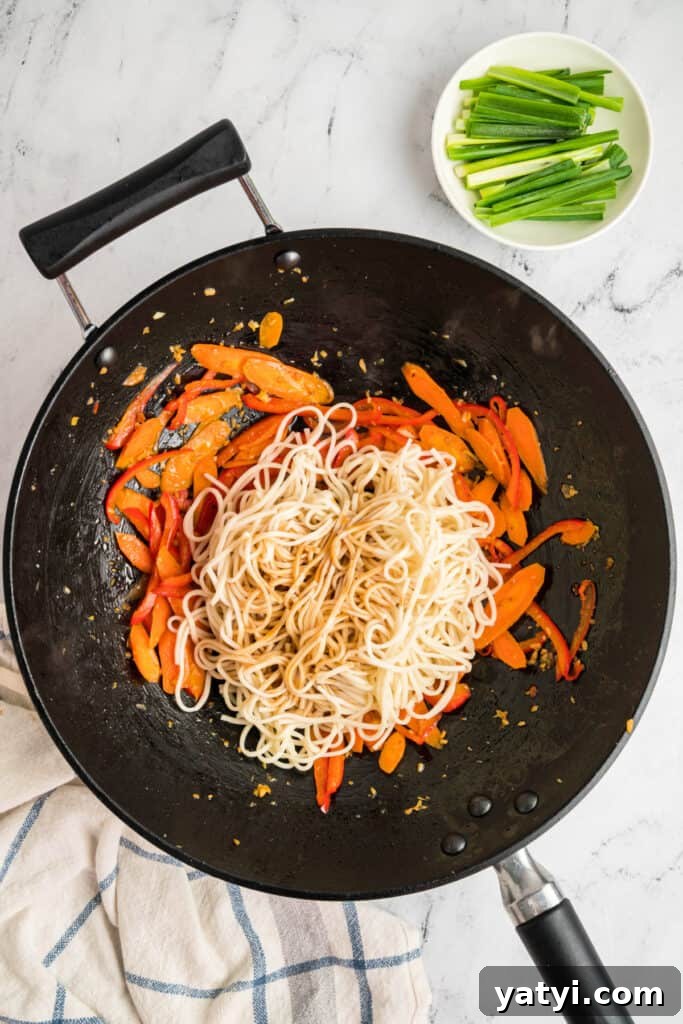 Garlic Shrimp Lo Mein Recipe — Quick Stir-Fry Noodles 12 Lo mein sauce poured over the noodles and vegetables in the wok, ready to be mixed.