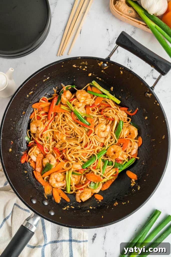 Garlic Shrimp Lo Mein Recipe — Quick Stir-Fry Noodles 15 Finished shrimp lo mein in a wok with shrimp, vegetables, and noodles coated in sauce.