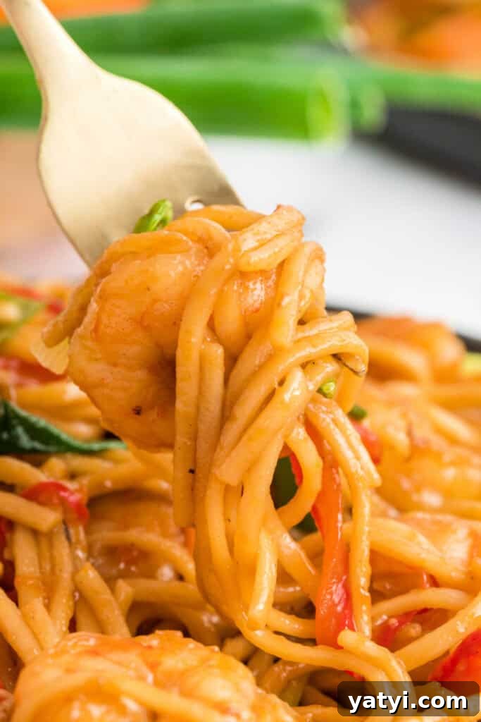 Garlic Shrimp Lo Mein Recipe — Quick Stir-Fry Noodles 16 Close-up of a fork twirling noodles and shrimp coated in sauce.
