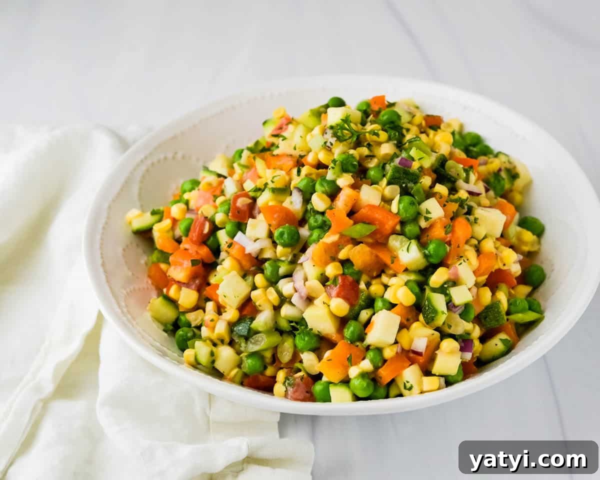 Summer Chopped Vegetable Salad with Creamy Shallot Vinaigrette 8 Serving the corn zucchini and bell pepper salad with peas in a white bowl.